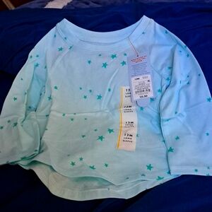 Long-sleeved size 12 months T shirt. Mint background with green stars all over.